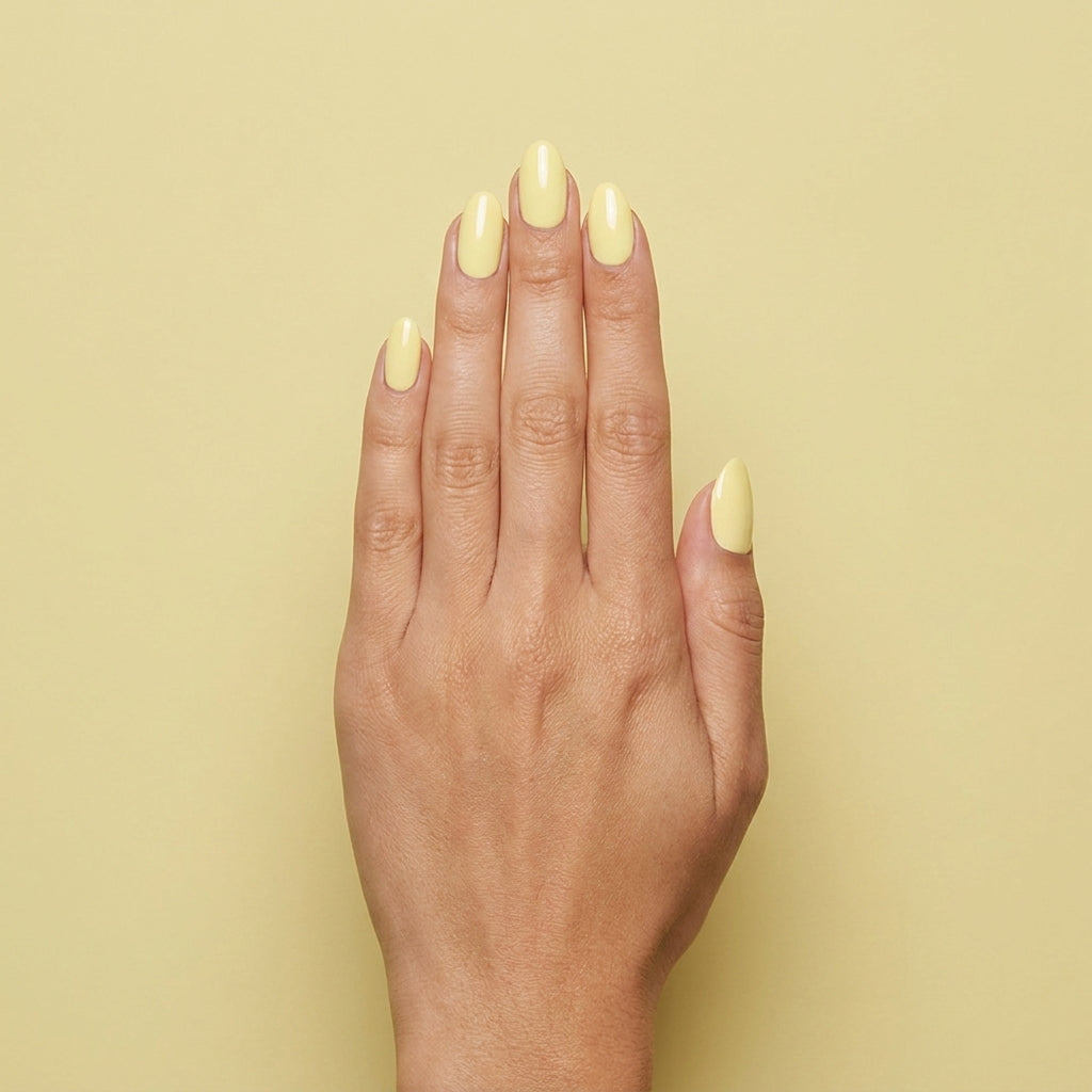 Mano con las uñas pintadas con esmalte en gel Gelish Let Down Your Hair, color Amarillos acabado Cream