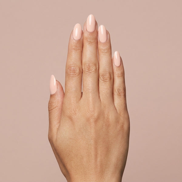 Mano con las uñas pintadas con esmalte en gel Gelish Barely Buff, color Nudes acabado Cream