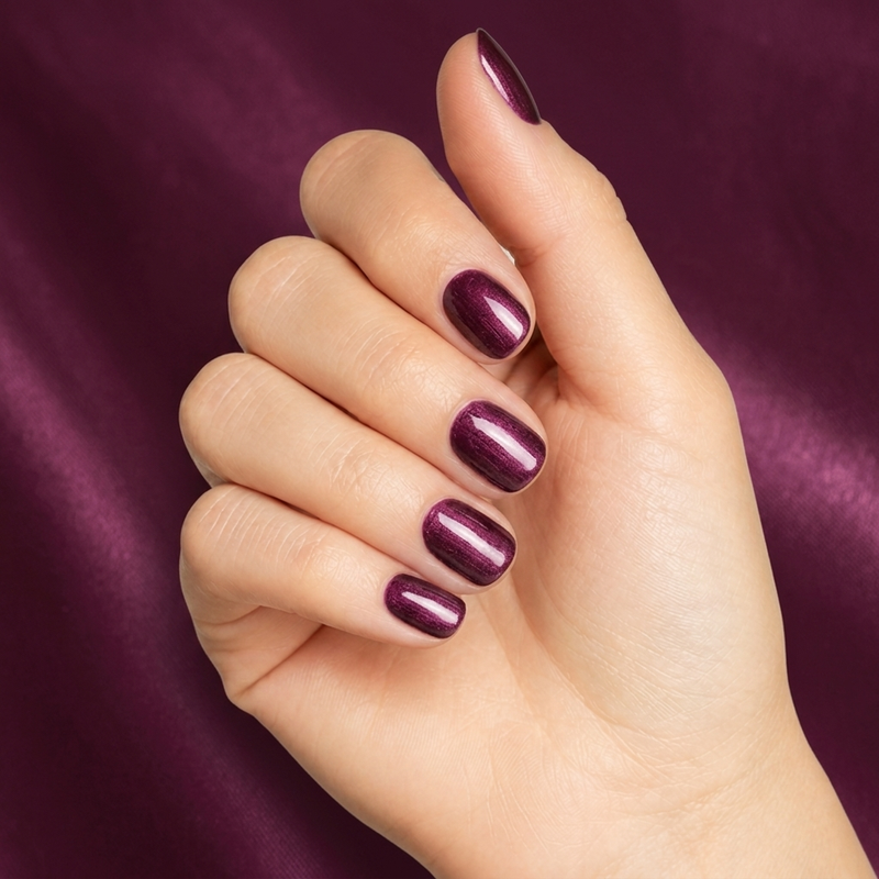 Mano con las uñas pintadas con esmalte en gel Gelish Samurai, color Morados acabado Shimmer