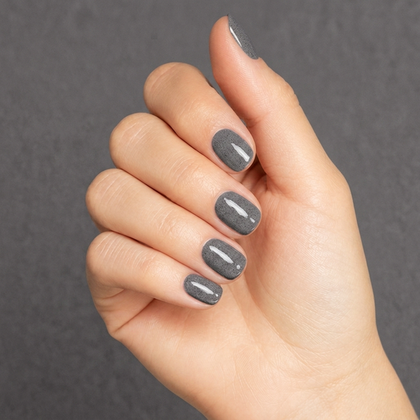 Mano con las uñas pintadas con esmalte en gel Gelish Midnight Caller, color Negros acabado Shimmer