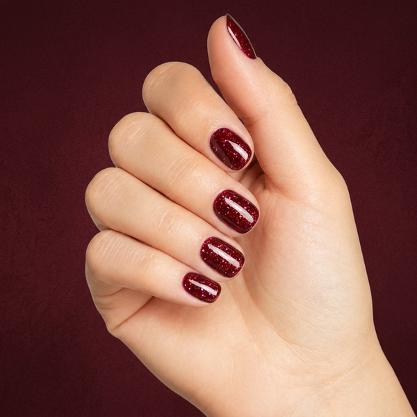 Mano con las uñas pintadas con esmalte en gel Gelish All Tied Up¿ With a Bow, color Rojos acabado Shimmer