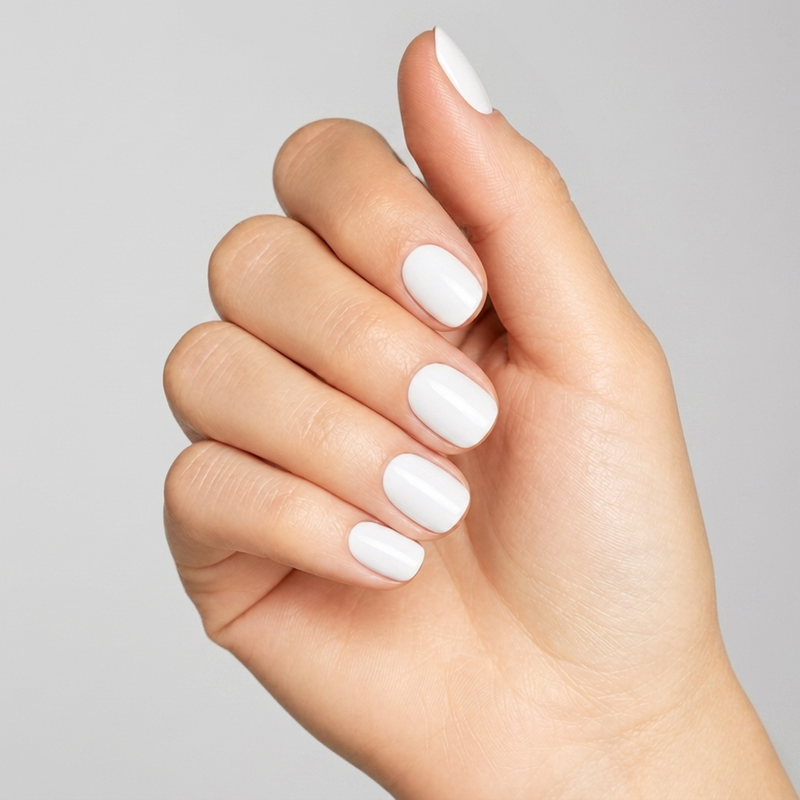 Mano con las uñas pintadas con esmalte tradicional Morgan Taylor Magic Within, color Blancos acabado Cream