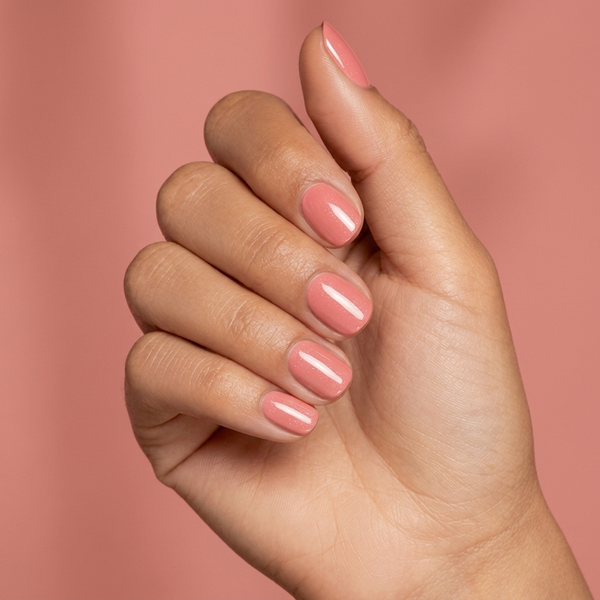 Mano con las uñas pintadas con esmalte tradicional Morgan Taylor Simple Sheer, color Nudes acabado Cream