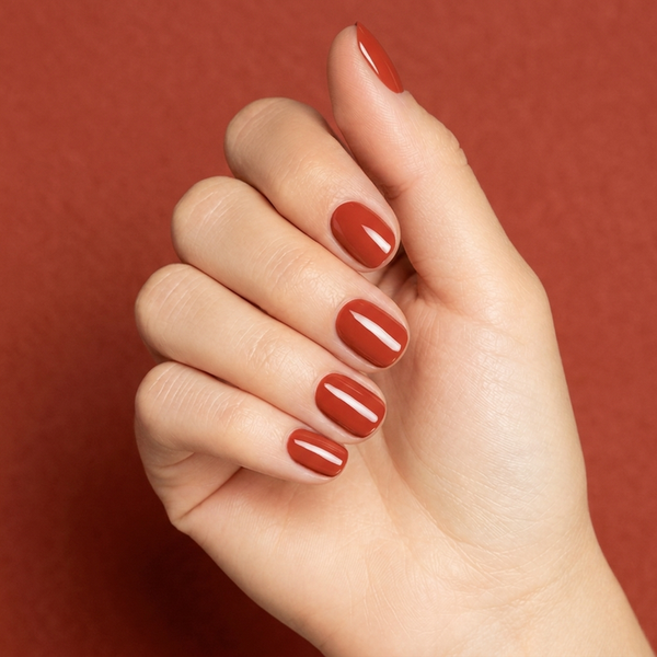 Mano con las uñas pintadas con esmalte tradicional Morgan Taylor Tiger Blossom, color Rojos acabado Cream