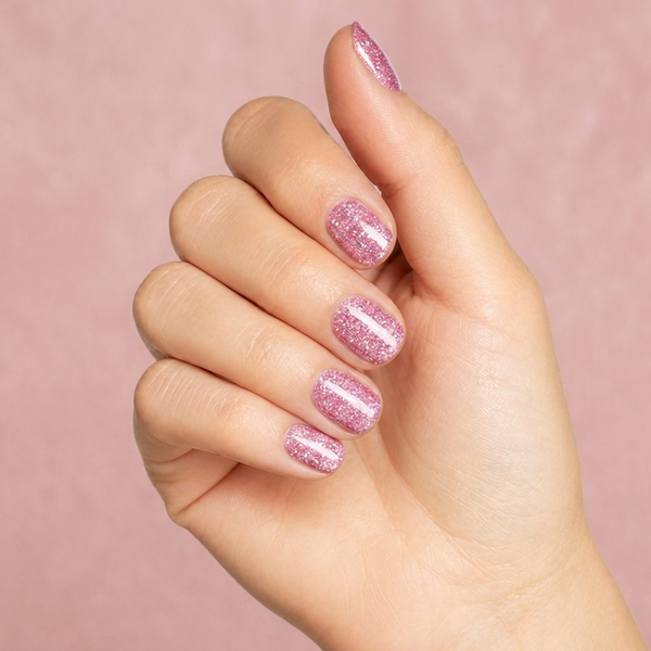 Mano con las uñas pintadas con esmalte tradicional Morgan Taylor June Bride, color Rosas acabado Glitter
