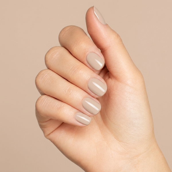 Mano con las uñas pintadas con esmalte tradicional Morgan Taylor Need a Tan, color Nudes acabado Cream