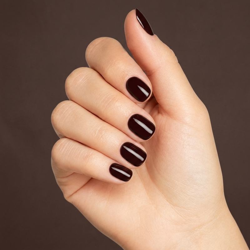 Mano con las uñas pintadas con esmalte tradicional Morgan Taylor Black Cherry Berry, color Borgoñas acabado Cream