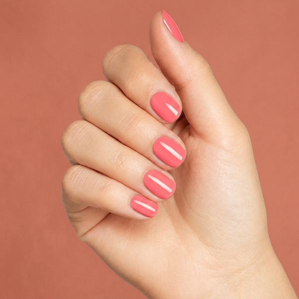 Mano con las uñas pintadas con esmalte tradicional Morgan Taylor Sweet Morning Dew, color Naranjas acabado Cream