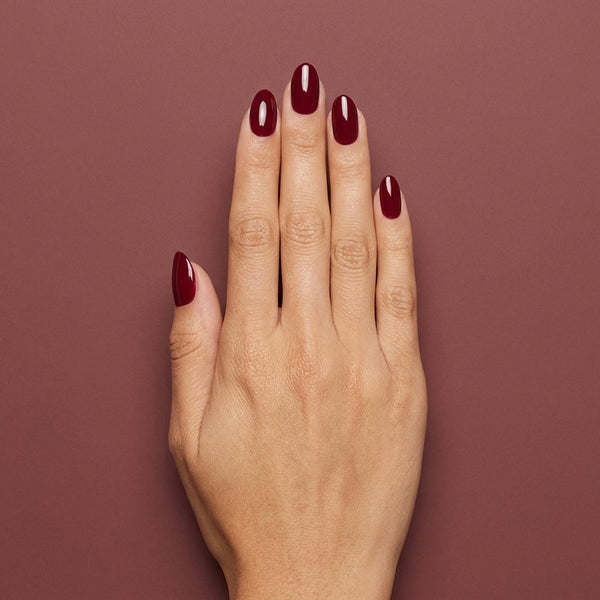 Mano con las uñas pintadas con esmalte tradicional Morgan Taylor Man Of The Moment, color Rojos acabado Cream