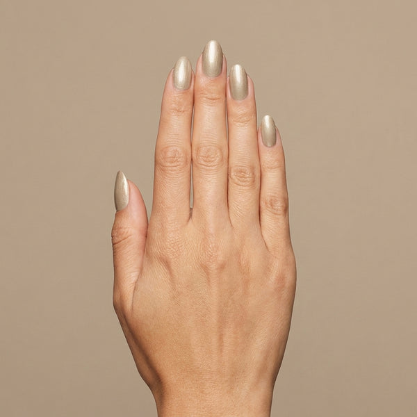 Mano con las uñas pintadas con esmalte tradicional Morgan Taylor Give Me Gold, color Nudes acabado Glitter