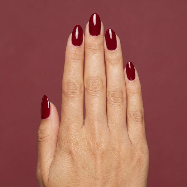 Mano con las uñas pintadas con esmalte tradicional Morgan Taylor Ruby Two-Shoes, color Rojos acabado Cream
