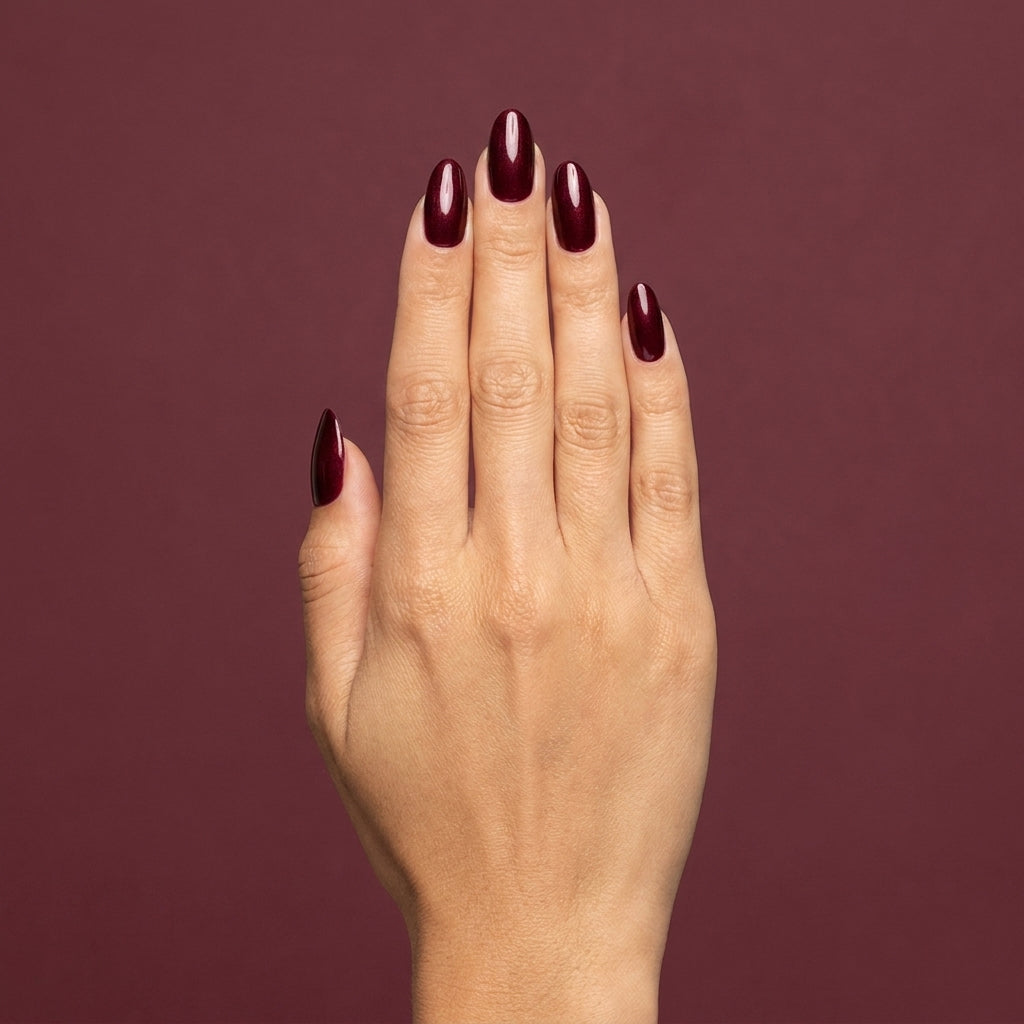 Mano con las uñas pintadas con esmalte tradicional Morgan Taylor I'm So Hot, color Borgoñas acabado Shimmer