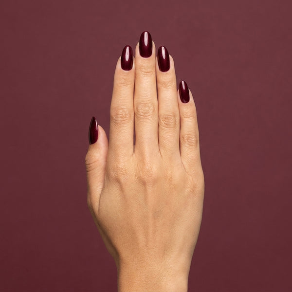 Mano con las uñas pintadas con esmalte tradicional Morgan Taylor I'm So Hot, color Borgoñas acabado Shimmer