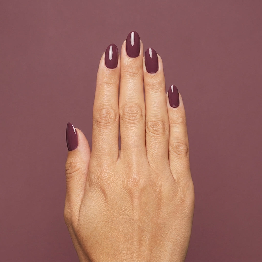 Mano con las uñas pintadas con esmalte tradicional Morgan Taylor Figure 8s & Heartbreaks, color Borgoñas acabado Cream