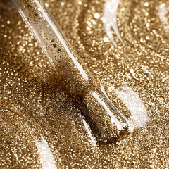 Primer plano del pincel con esmalte en gel Gelish Give Me Gold, color Nudes acabado Glitter, textura del color