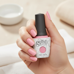 Mano sosteniendo el frasco de esmalte en gel Gelish Look At You Pink-Achu!, color Rosas acabado Cream, con las uñas pintadas del mismo tono