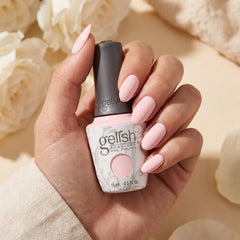 Mano sosteniendo el frasco de esmalte en gel Gelish Once Upon a Mani, color Rosas acabado Cream, con las uñas pintadas del mismo tono