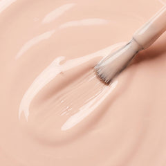 Primer plano del pincel con esmalte en gel Gelish Barely Buff, color Nudes acabado Cream, textura del color