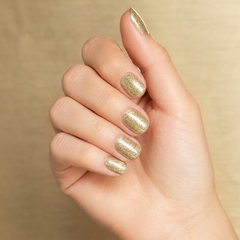 Mano con las uñas pintadas con esmalte en gel Gelish Star Quality, color Amarillos acabado Glitter