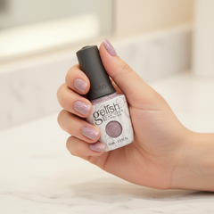 Mano sosteniendo el frasco de esmalte en gel Gelish Time To Sparkle, color Blancos acabado Glitter, con las uñas pintadas del mismo tono