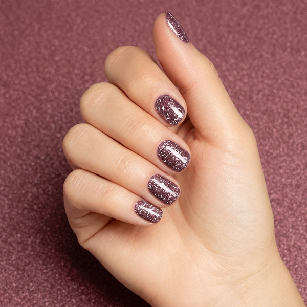 Mano con las uñas pintadas con esmalte en gel Gelish Mesmerized By You, color Borgoñas acabado Glitter