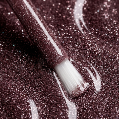 Primer plano del pincel con esmalte en gel Gelish Mesmerized By You, color Borgoñas acabado Glitter, textura del color