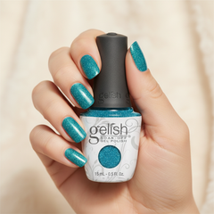 Mano sosteniendo el frasco de esmalte en gel Gelish I'll Shine For You, color Azules acabado Shimmer, con las uñas pintadas del mismo tono
