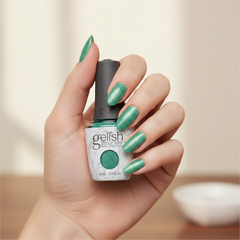 Mano sosteniendo el frasco de esmalte en gel Gelish Mint To Sparkle, color Verdes acabado Shimmer, con las uñas pintadas del mismo tono