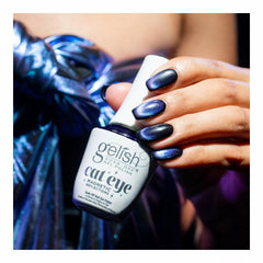 Mano sosteniendo el frasco de esmalte en gel Gelish Cat Eye - Blue Eclipse
