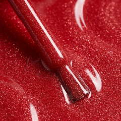 Primer plano del pincel con esmalte en gel Gelish Hold The Camera, color Rojos acabado Glitter, textura del color