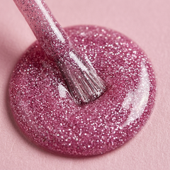 Primer plano del pincel con esmalte en gel Gelish My Best Selfie, color Rosas acabado Glitter, textura del color