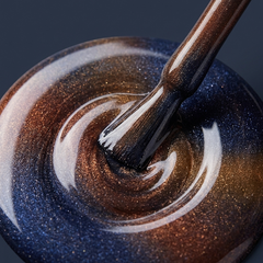 Primer plano del pincel con esmalte en gel Gelish Aurora - Space Dust, color Azules acabado Cat Eye, textura del color