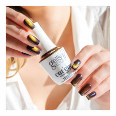 Mano con las uñas en Gelish Aurora Cat Eye Space Dust, azul marino con remolino dorado, sosteniendo el frasco Aurora Cat Eye Magnet Gel