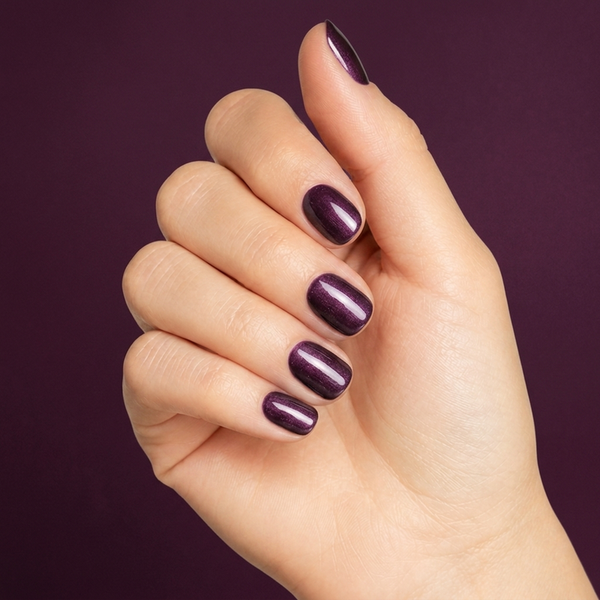 Mano con las uñas pintadas con esmalte en gel Gelish Aurora - Sky On Fire, color Morados acabado Cat Eye