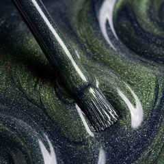 Primer plano del pincel con esmalte en gel Gelish Aurora - Big Bang For Your Buck, color Verdes acabado Cat Eye, textura del color