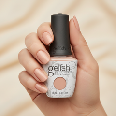 Mano sosteniendo el frasco de esmalte en gel Gelish Forever Beauty, color Nudes acabado Cream, con las uñas pintadas del mismo tono