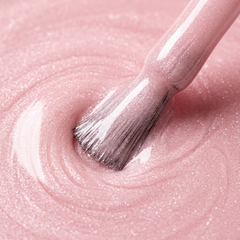 Primer plano del pincel con esmalte en gel Gelish Ambience, color Rosas acabado Shimmer, textura del color