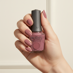 Mano sosteniendo el frasco de esmalte en gel Gelish Exhale, color Mauves acabado Cream, con las uñas pintadas del mismo tono