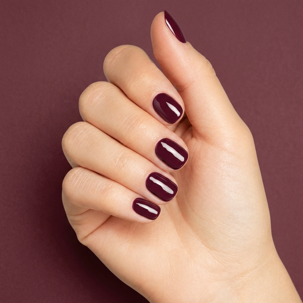 Mano con las uñas pintadas con esmalte en gel Gelish Stand Out, color Borgoñas acabado Cream