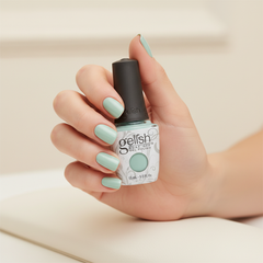 Mano sosteniendo el frasco de esmalte en gel Gelish Sea Foam, color Verdes acabado Cream, con las uñas pintadas del mismo tono