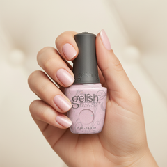 Mano sosteniendo el frasco de esmalte en gel Gelish June Bride, color Rosas acabado Glitter, con las uñas pintadas del mismo tono