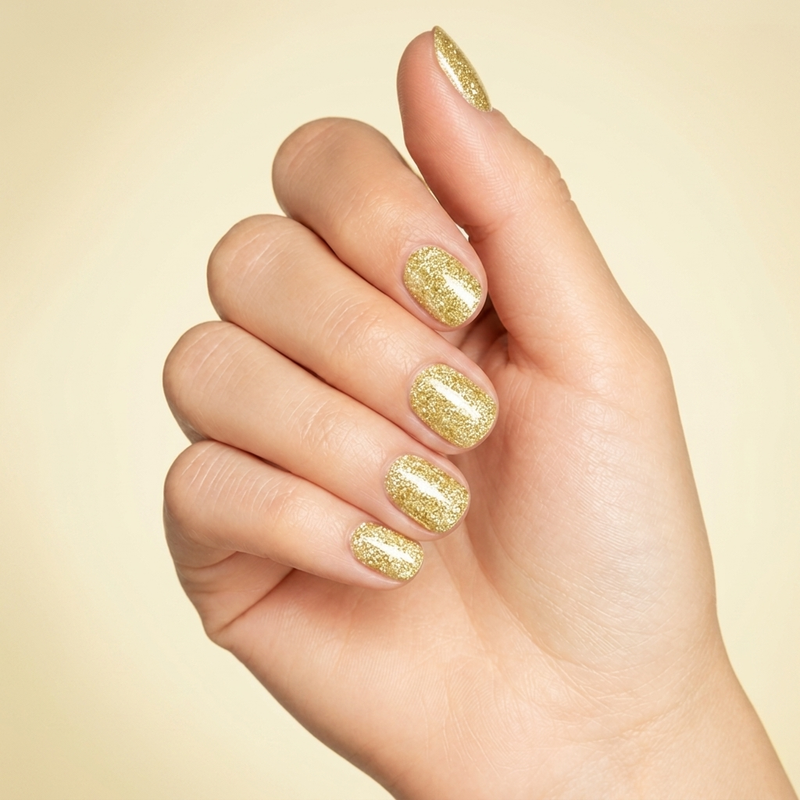 Mano con las uñas pintadas con esmalte en gel Gelish Bronzed, color Amarillos acabado Glitter