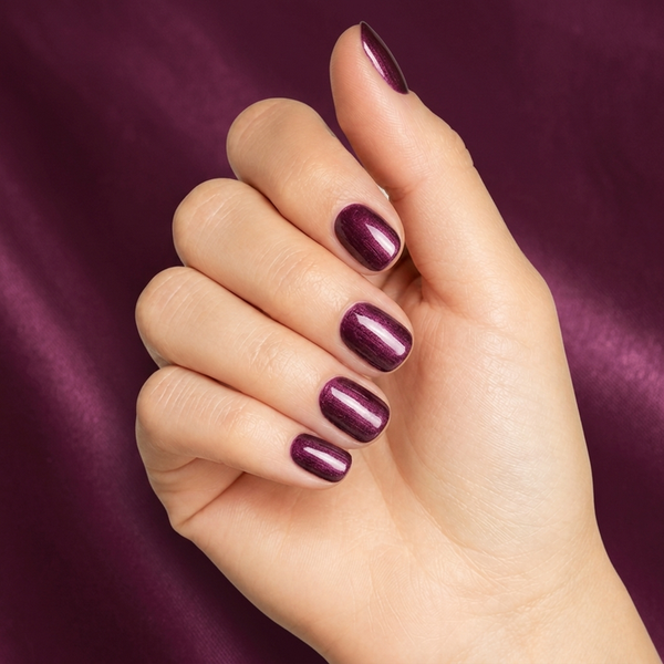 Mano con las uñas pintadas con esmalte en gel Gelish Samurai, color Morados acabado Shimmer
