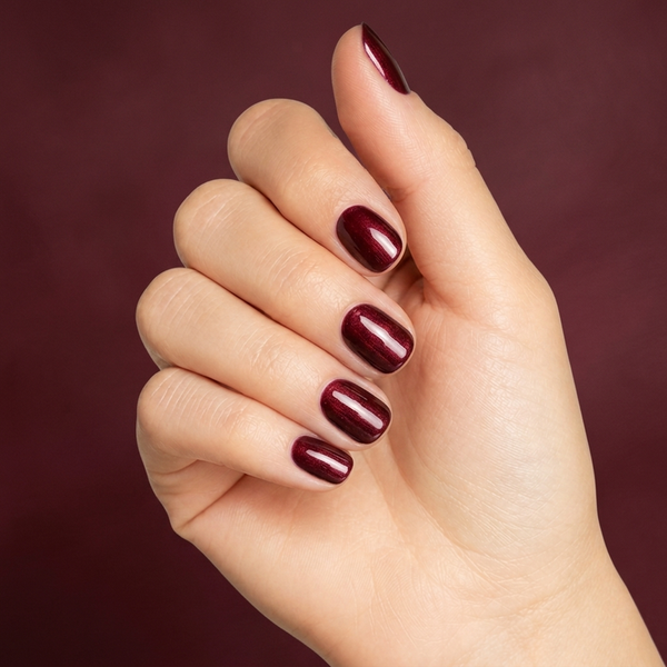 Mano con las uñas pintadas con esmalte en gel Gelish Rose Garden, color Rojos acabado Shimmer