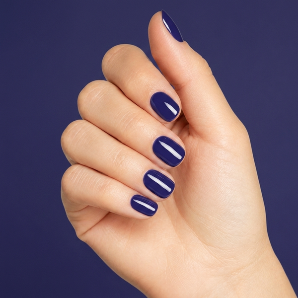 Mano con las uñas pintadas con esmalte en gel Gelish After Dark, color Azules acabado Cream