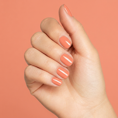 Mano con las uñas pintadas con esmalte en gel Gelish Sweet Morning Dew, color Naranjas acabado Cream