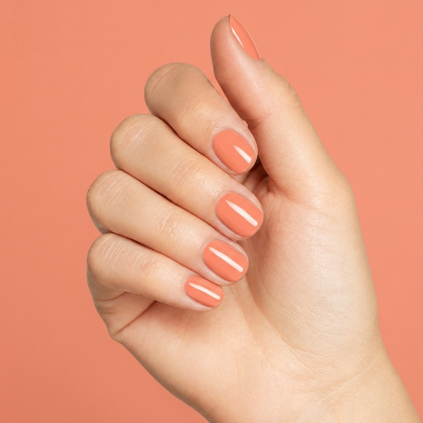 Mano con las uñas pintadas con esmalte en gel Gelish Sweet Morning Dew, color Naranjas acabado Cream
