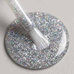 Primer plano del pincel con esmalte en gel Gelish Am I Making You Gelish?, color Blancos acabado Glitter, textura del color