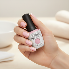 Mano sosteniendo el frasco de esmalte en gel Gelish Tutus & Tights, color Rosas acabado Cream, con las uñas pintadas del mismo tono