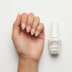 Mano con uñas naturales junto al frasco de Gelish PH Bond Nail Prep